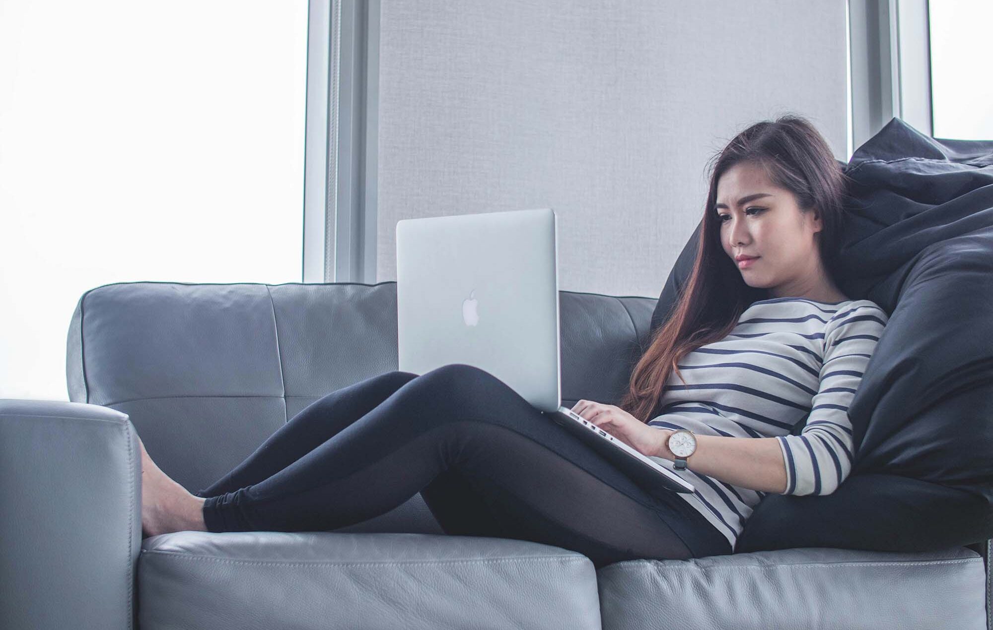 woman-sitting-on-sofa-while-using-MacBook-Pro-1